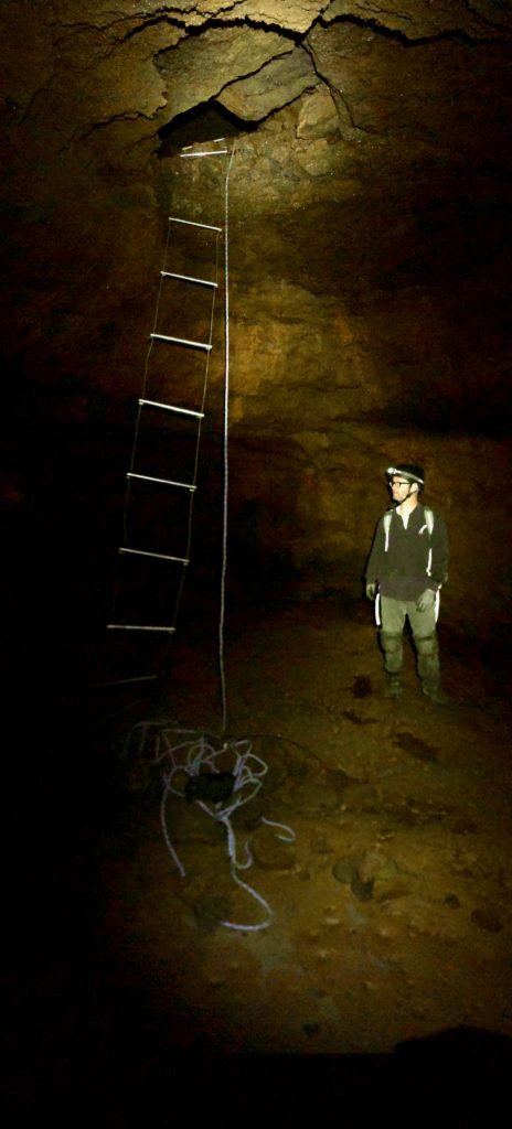 Inside the Monster room. Mann standing next to ropes. Hole at top.
