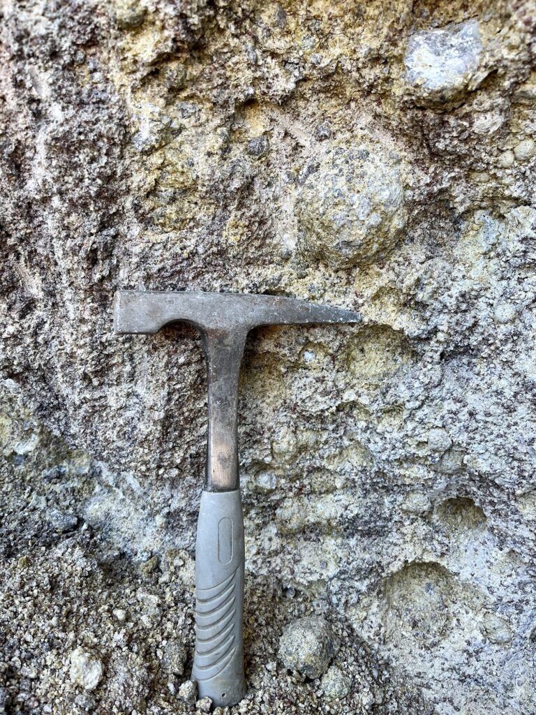 rock pick next to thunderegg still in the wall